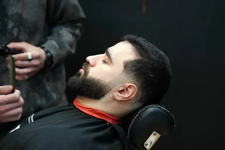 AB Barbers, Putney. A beard trim with the customer leaning back in the chair.