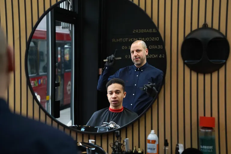 AB Barbers, Putney. The round mirror catches barber and customer.