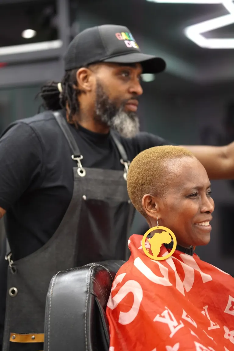 Another Level Barbers, Anerley. Barber and customer share a joke at the chair.