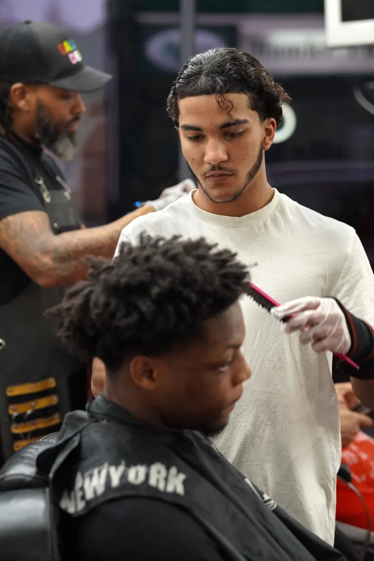 Another Level Barbers, Anerley. The barber checks the shape mid-cut.