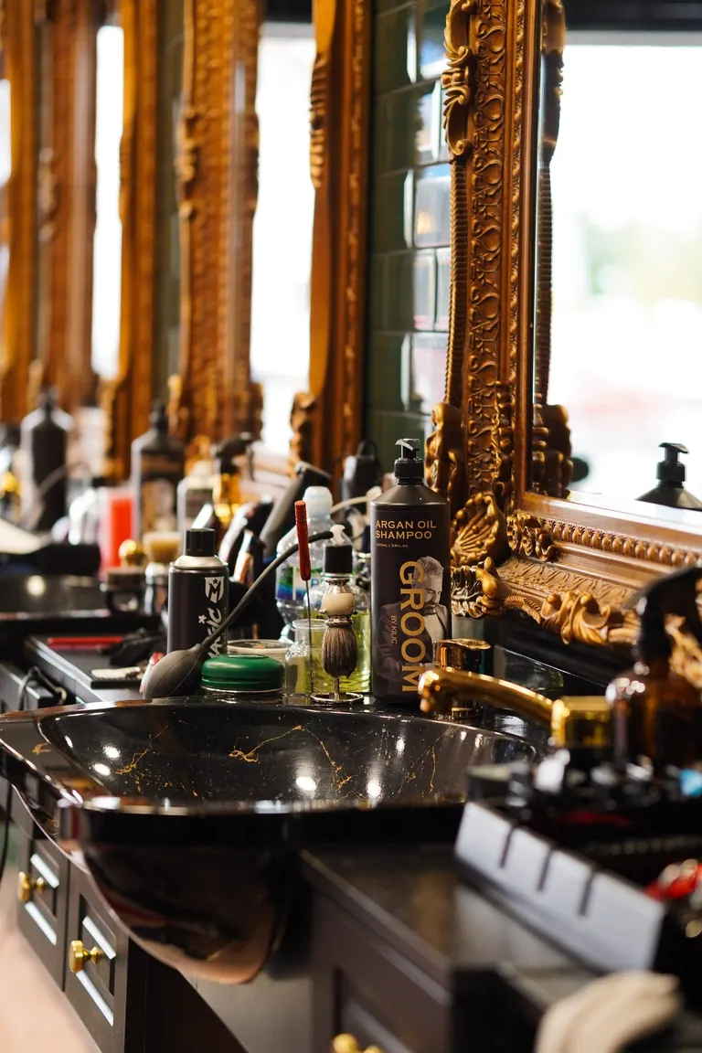 Groom Barbers, Lingfield, Surrey. A run of gold mirrors down the length of the shop.