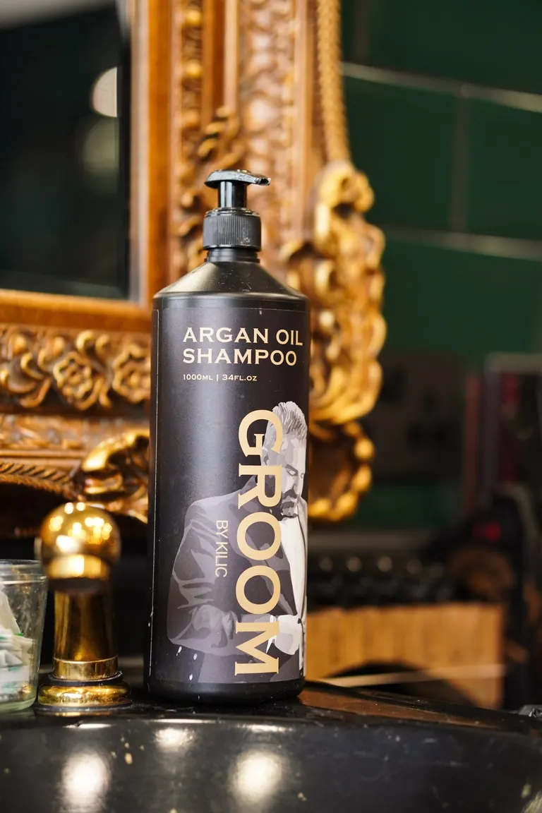 Groom Barbers, Lingfield, Surrey. Groom argan oil shampoo in front of a gold frame.