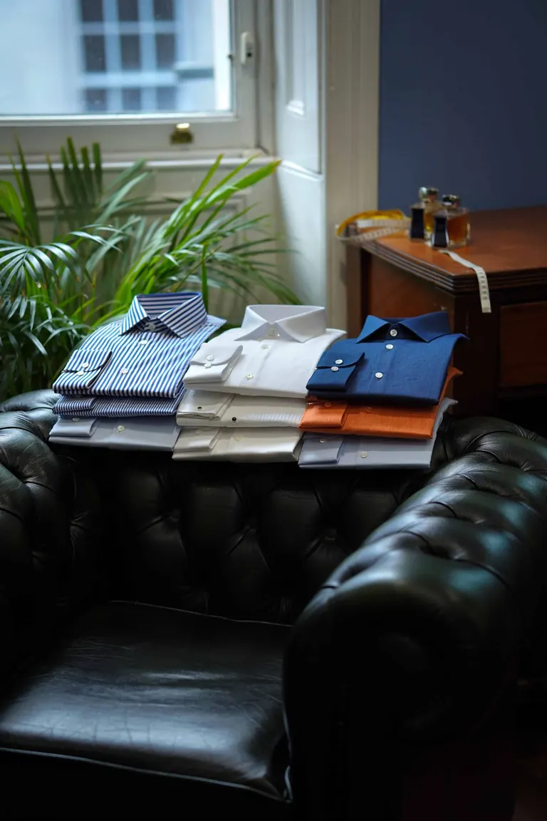 Hidalgo Brothers, Savile Row, London. Folded shirts laid out on a Chesterfield by the window.