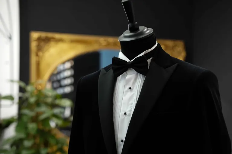 Hidalgo Brothers, Savile Row, London. A dinner jacket in front of a gilt mirror.