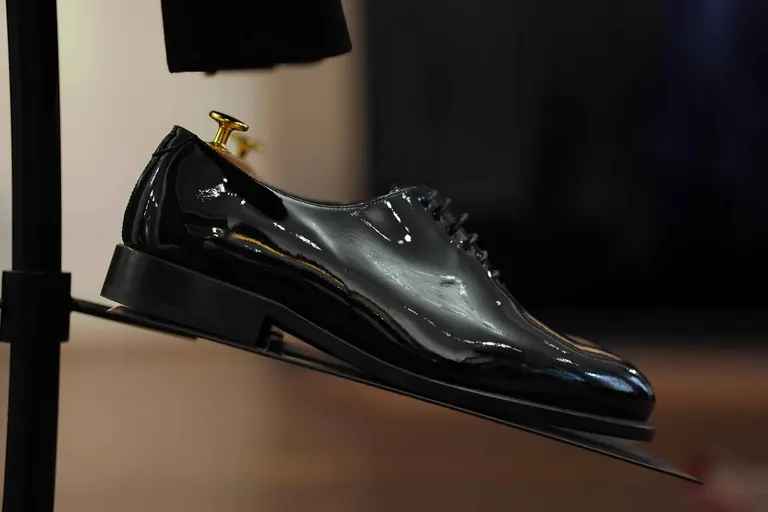 Hidalgo Brothers, Savile Row, London. A patent leather shoe lit on a display arm.