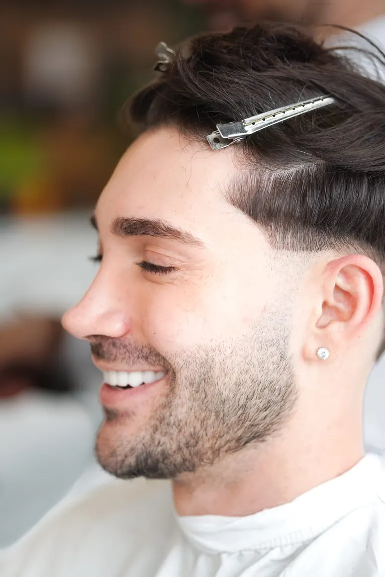 The Axe Club, London. A customer smiles with clips still in his hair.